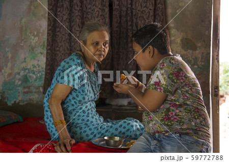 young boy feeding his grandmother young boy feeding his grandmother 59772788
