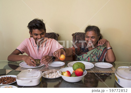 Grandmother serving to her grandson on the dining table at home. 59772852