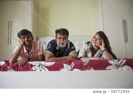 Portrait of a family relaxing in their bedroom at home. 59772950