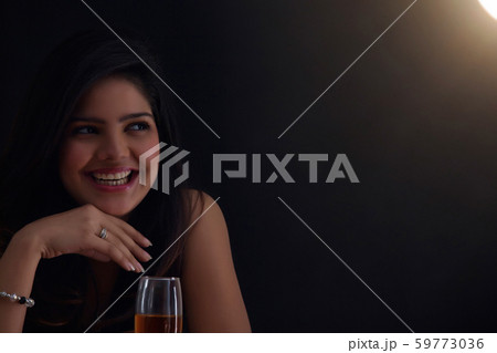 Woman with a glass of wine smiling Woman with a glass of wine smiling 59773036