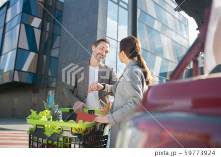 Husband and wife standing near their car after shopping in the supermarket 59773924