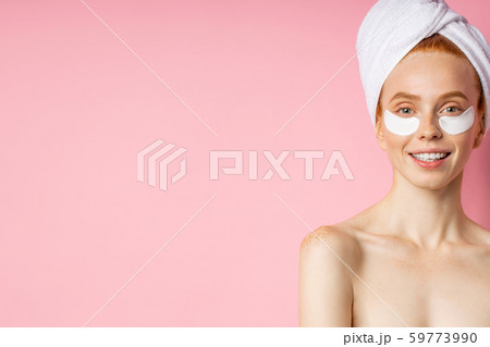 Young woman with patches under eyes isolated on pink background 59773990