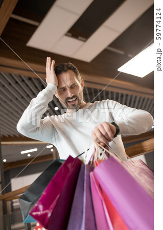 Bearded man feeling shocked while waiting for wife for too long 59774124