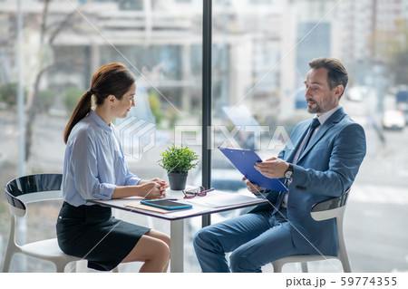Secretary smiling while speaking with businessman and discussing tasks for the day Secretary smiling while speaking with businessman and discussing tasks for the day 59774355