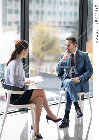 Rich entrepreneur enjoying talk with young experienced journalist 59774430