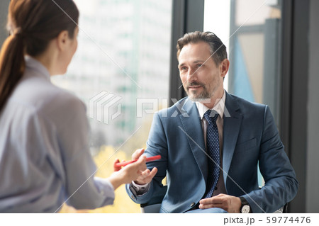 Affluent entrepreneur speaking with journalist while giving interview Affluent entrepreneur speaking with journalist while giving interview 59774476
