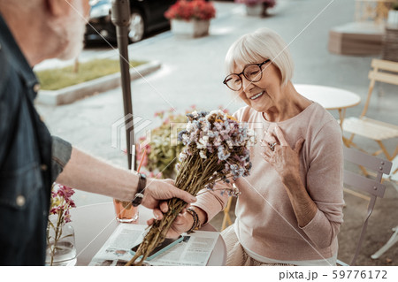 Nice joyful woman being happy to receive a bouquet 59776172