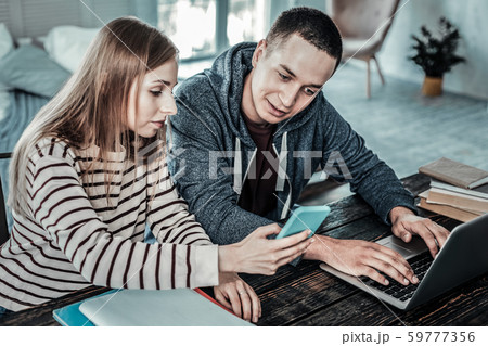 Nice positive man looking at her girlfriends smartphone 59777356