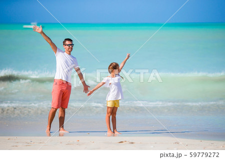 Little girl and happy dad having fun during beach vacation Little girl and happy dad having fun during beach vacation 59779272
