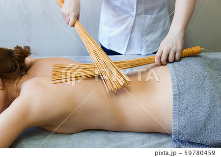 Back massage in the massage room with bamboo Back massage in the massage room with bamboo 59780459