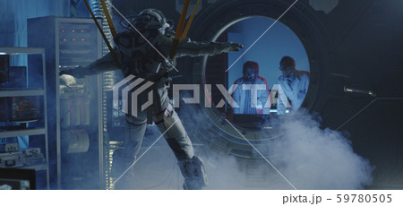 Astronaut moving limbs while hanging on bands 59780505