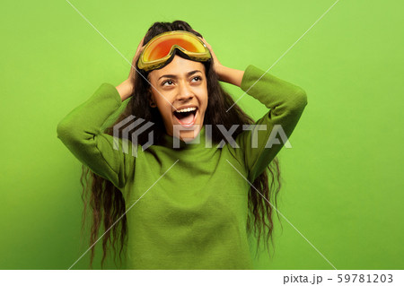 African-american young woman's portrait in ski mask on green background 59781203