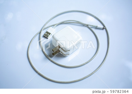 USB power adapter for devices, Charger Cable on white acrylic table background, Close up & Macro shot, Selective focus, Technology, Business concept 59782364