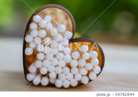 White plastic cotton buds with  Shape " Heart " brown box on wood table texture background, Close up & Macro shot, Selective focus, About Cleaning Body, Healthcare concept 59782694