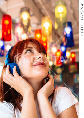 Happy girl listens to music on headphones in cafe 59784920