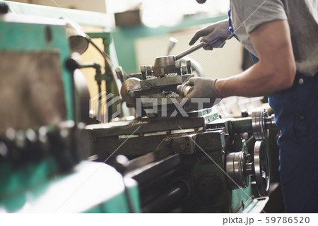 Strong hands hold the steel part. In the old factory. Strong hands hold the steel part. In the old factory. 59786520
