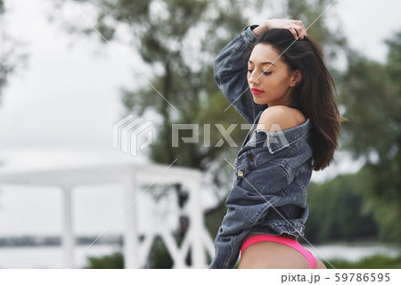 Sexy brunette girl posing on the beach. Concept of sports model Sexy brunette girl posing on the beach. Concept of sports model 59786595