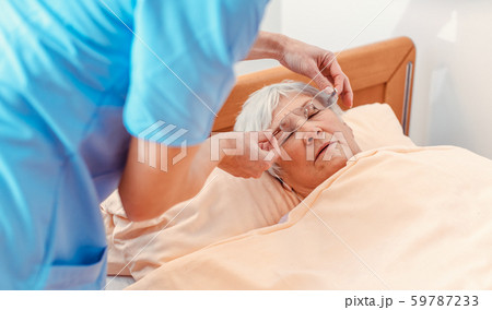 Nurse taking care of sleeping senior woman in the nursing home Nurse taking care of sleeping senior woman in the nursing home 59787233