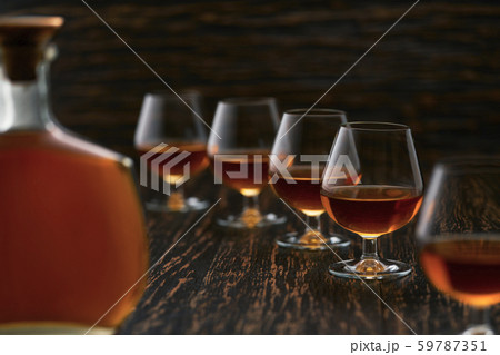 glasses of cognac on a wooden table with the 59787351