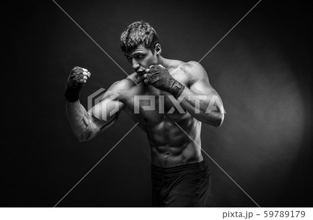 Handsome topless sportsman practicing punches Handsome topless sportsman practicing punches 59789179