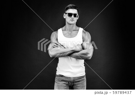 Handsome muscular man in dark glasses and a white shirt. 59789437