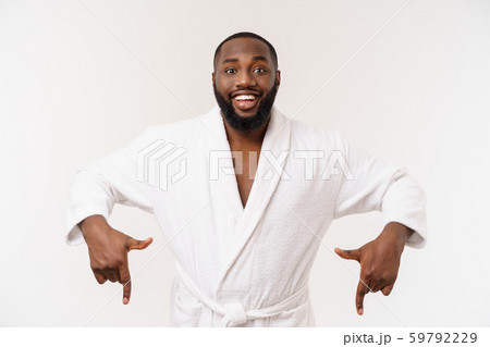 Black guy wearing a bathrobe pointing finger with surprise and happy emotion. Isolated over whtie 59792229