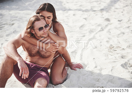 A romantic couple on the beach in a swimsuit, beautiful sexy young people 59792576