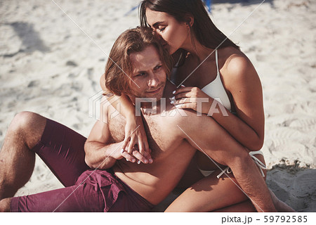 A romantic couple on the beach in a swimsuit, beautiful sexy young people A romantic couple on the beach in a swimsuit, beautiful sexy young people 59792585
