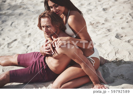 A romantic couple on the beach in a swimsuit, beautiful sexy young people A romantic couple on the beach in a swimsuit, beautiful sexy young people 59792589