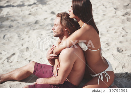 A romantic couple on the beach in a swimsuit, beautiful sexy young people A romantic couple on the beach in a swimsuit, beautiful sexy young people 59792591
