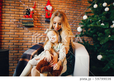 mother and daughter sitting by the christmas tree mother and daughter sitting by the christmas tree 59799036