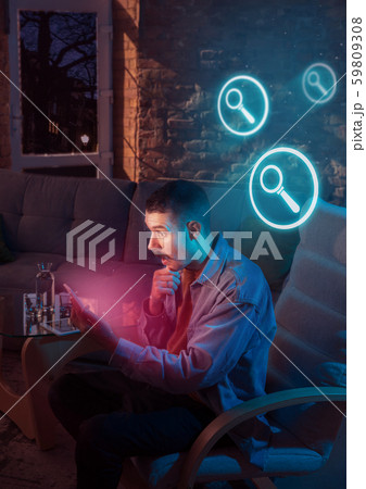 Man using gadget and receive neon notifications at home at night 59809308