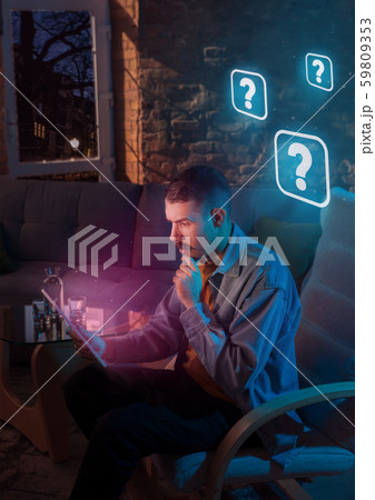 Man using gadget and receive neon notifications at home at night 59809353