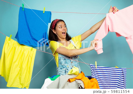 Funny and beautiful housewife doing housework on blue background 59811554