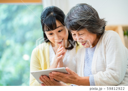 タブレット端末を操作する親子　母子　シニア女性　ミドル女性　2人 59812922