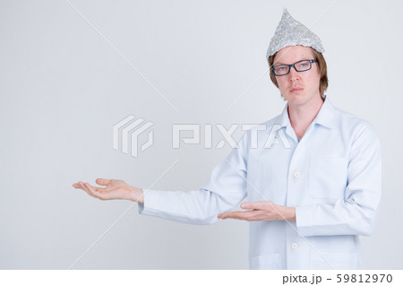 Young man doctor with tinfoil hat showing something 59812970