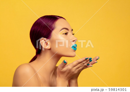 Portrait of beautiful young woman with bright make-up isolated on yellow studio background 59814301
