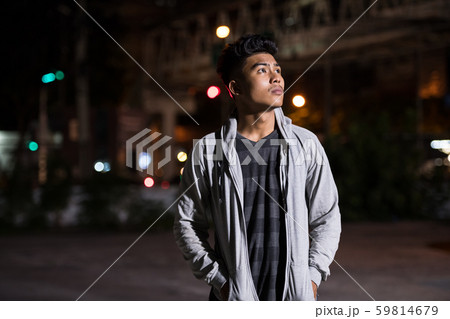 Young Asian man thinking in the city streets at night Young Asian man thinking in the city streets at night 59814679