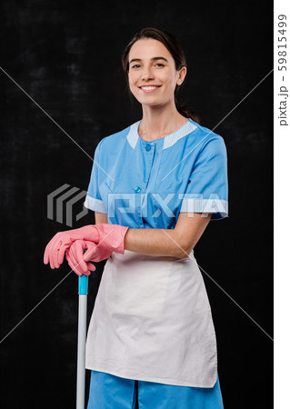 Pretty young hotel room cleaning staff in blue uniform and rubber gloves 59815499