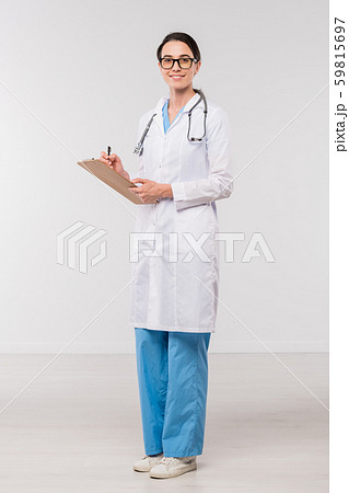 Young confident clinician in whitecoat filling in medical document in isolation 59815697