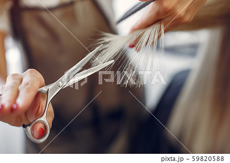 Hairdresser cut hair her client in a hair salon Hairdresser cut hair her client in a hair salon 59820588