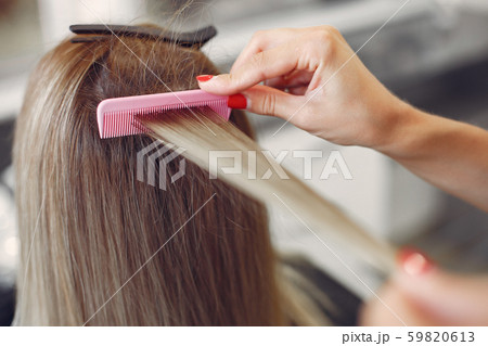 Hairdresser does hairstyle for her client Hairdresser does hairstyle for her client 59820613
