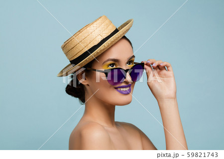 Portrait of beautiful young woman with bright make-up isolated on blue studio background 59821743