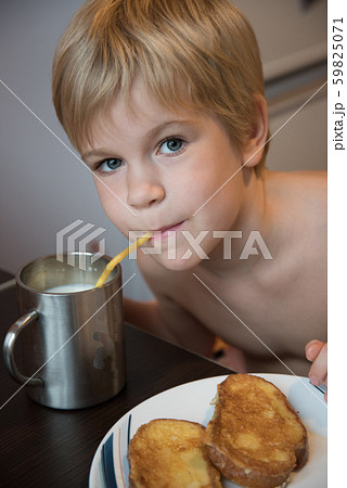 The child drinks milk at breakfast. Milk and croutons. 59825071