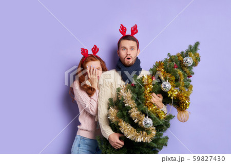 Fearful couple in festive room at christmas tree Fearful couple in festive room at christmas tree 59827430