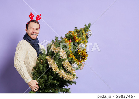Man in red christmas horn holding Christmas tree Man in red christmas horn holding Christmas tree 59827467