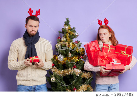 Dissatisfied man with small gift box Dissatisfied man with small gift box 59827488