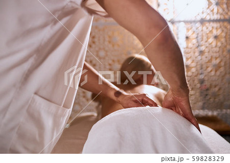Masseur doing massage on woman body in spa salon Masseur doing massage on woman body in spa salon 59828329
