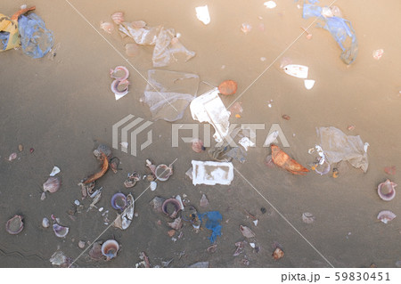 Trash, plastic, garbage, bottle, bag... environmental pollution on sandy beach. Royalty high-quality stock photo image of trash, plastic bag, bottle on beach. Waste that polluted the ocean environment Trash, plastic, garbage, bottle, bag... environmental pollution on sandy beach. Royalty high-quality stock photo image of trash, plastic bag, bottle on beach. Waste that polluted the ocean environment 59830451