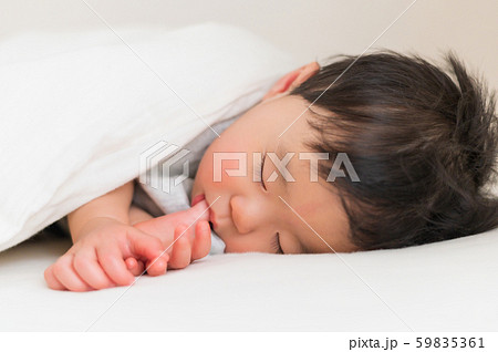 赤ちゃん おひるね 乳児 乳幼児 昼寝 寝相 指しゃぶりの写真素材